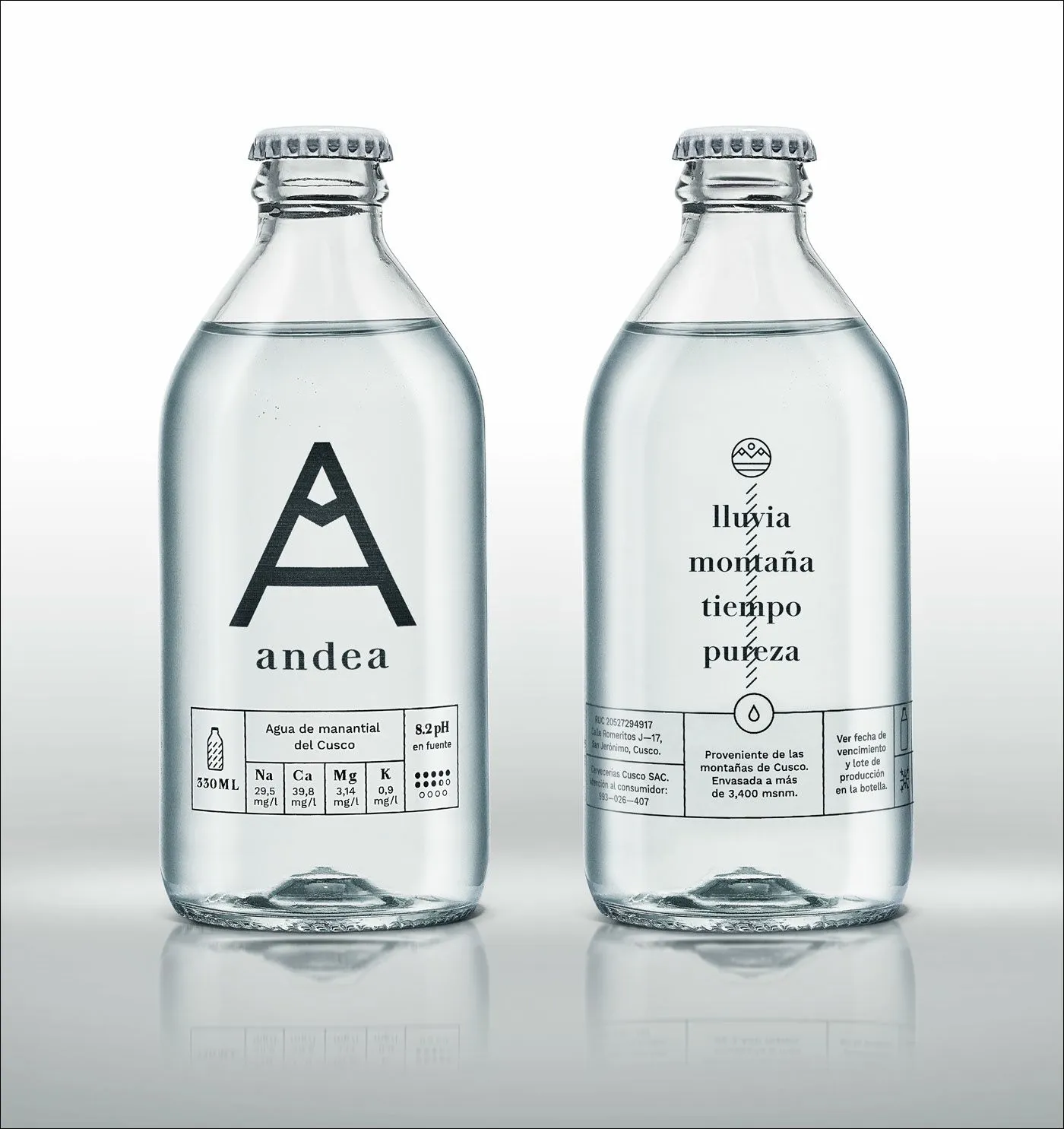Botella de vidrio de agua mineral Andea con los Andes cusqueños de fondo