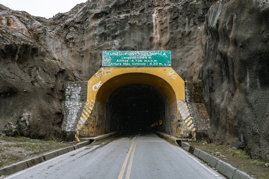 Tunnel in the Andes mountains of Peru, marked by a yellow entrance and a sign.