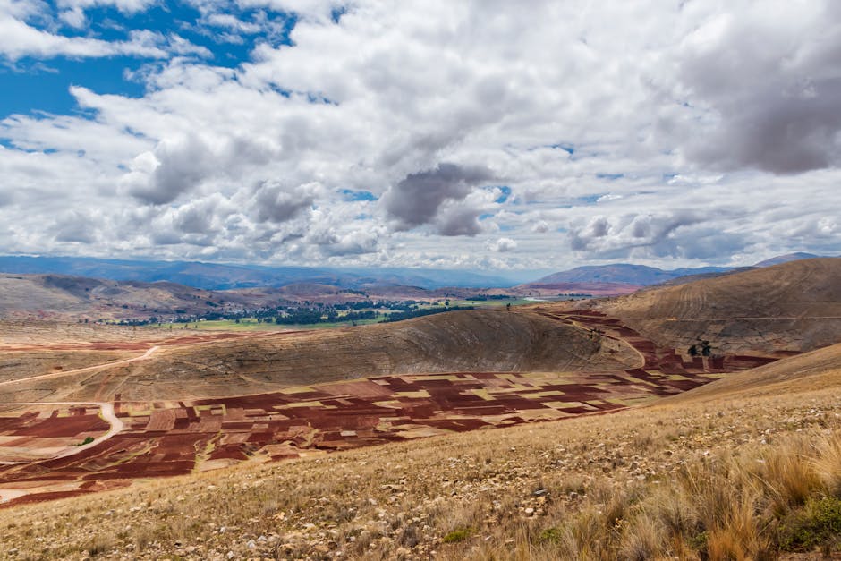 Vista aérea de los campos de cultivo en Jauja, Perú, bajo un cielo luminoso.