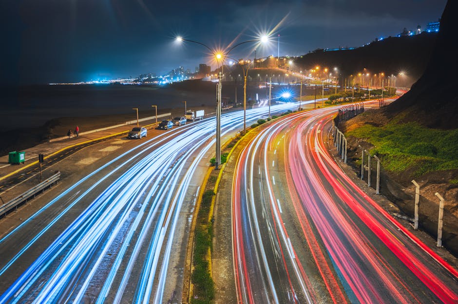 Vibrant light trails captured on a Lima highway at night, showcasing urban life.