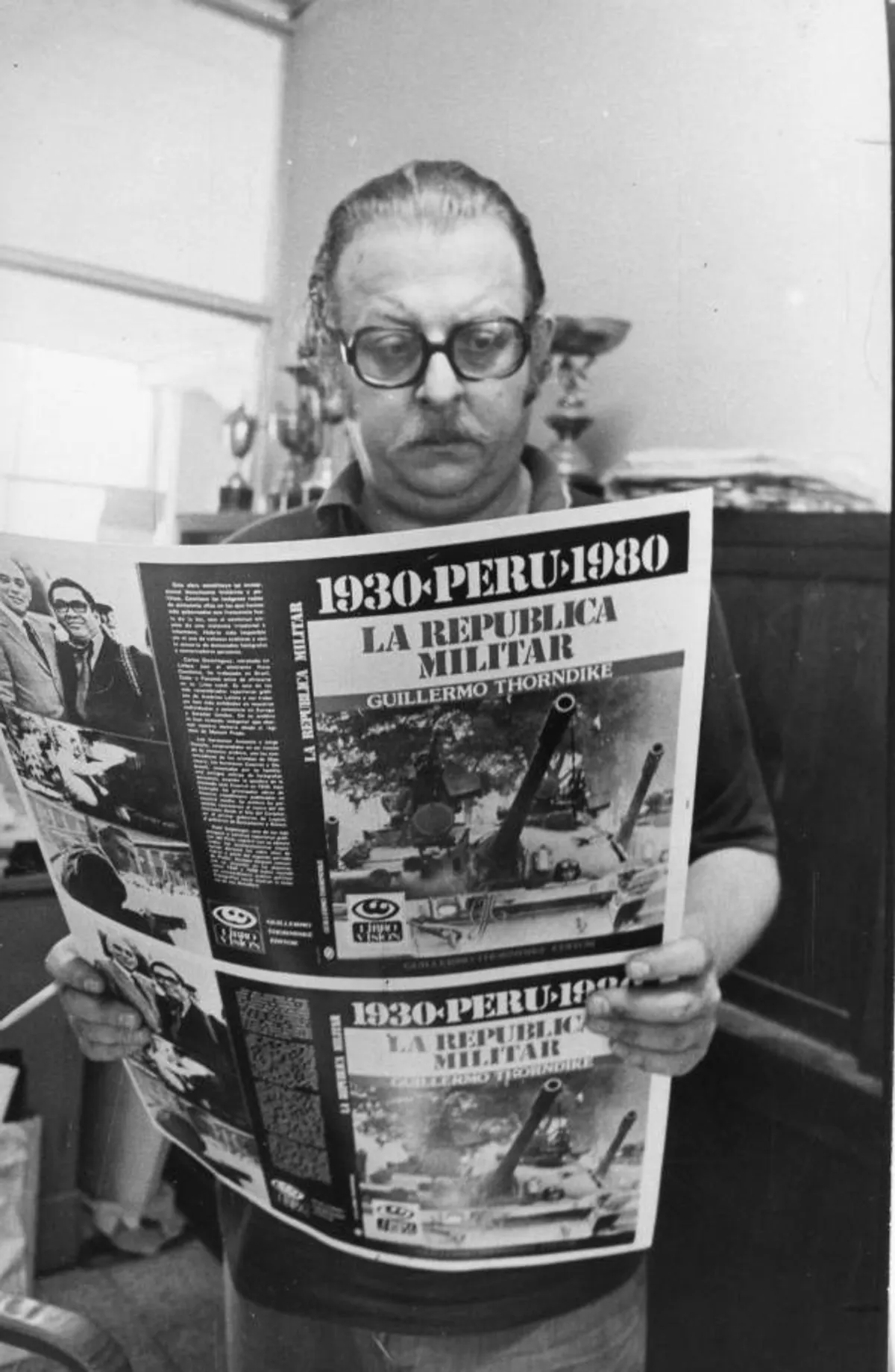 Guillermo Thorndike Losa sosteniendo la portada de su libro "La República Militar, 1930-1980"