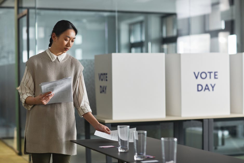 Mujer organizando papeletas de votación en una mesa electoral.